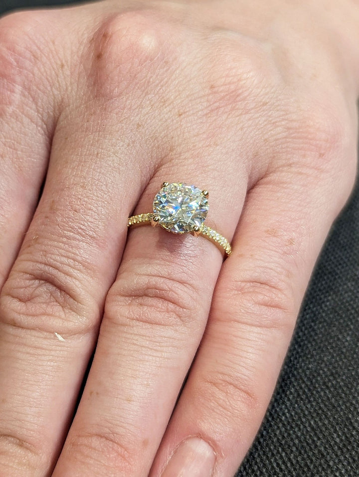 Round hidden halo diamond ring displayed on jewelry stand