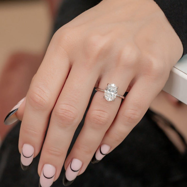Oval hidden halo engagement ring finished in polished solid gold