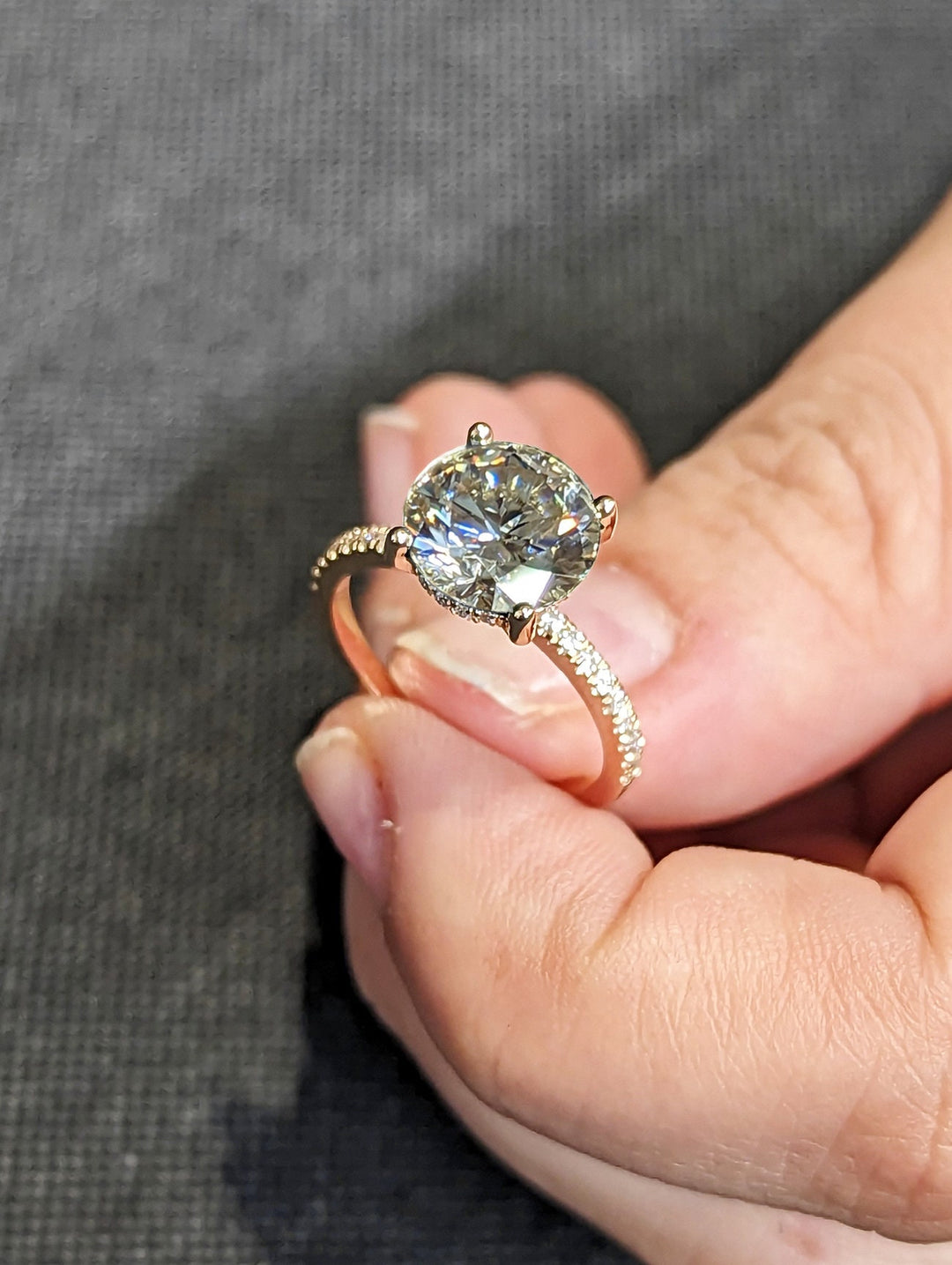 Detailed close-up of round hidden halo diamond engagement ring