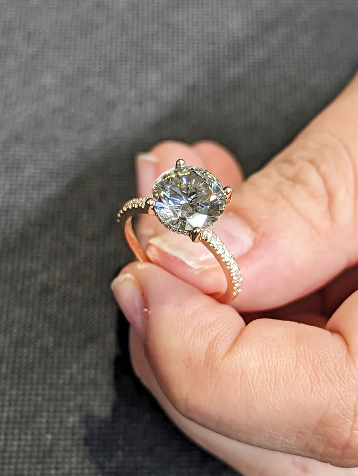 Detailed close-up of round hidden halo diamond engagement ring