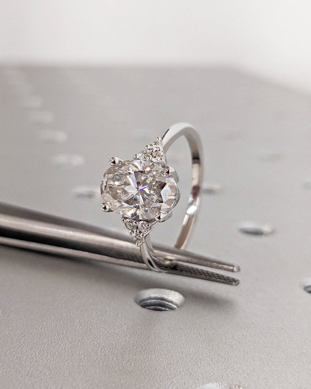 Oval cluster engagement ring viewed from the side