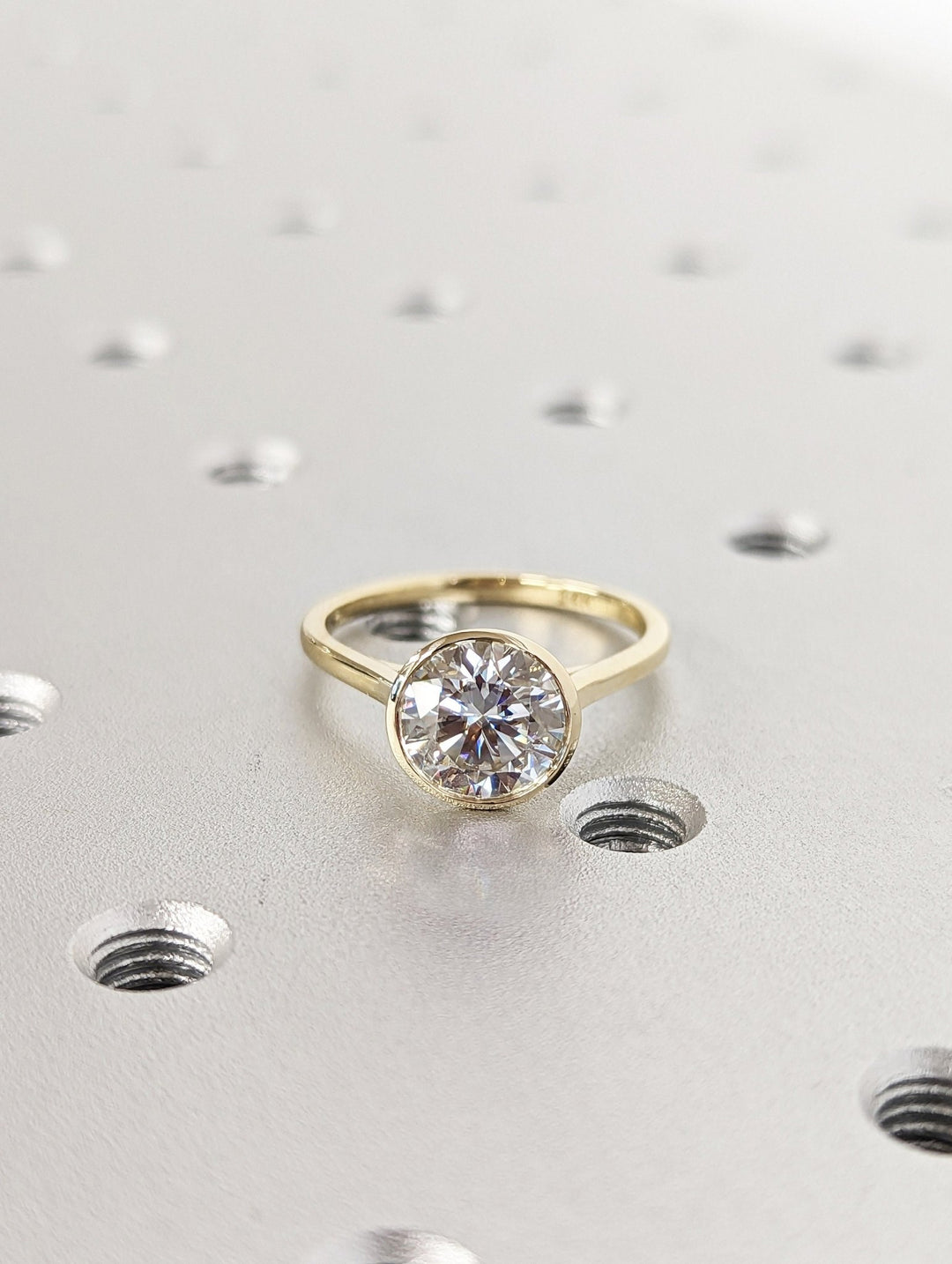 Round bezel engagement ring shown on hand for true-to-life sizing