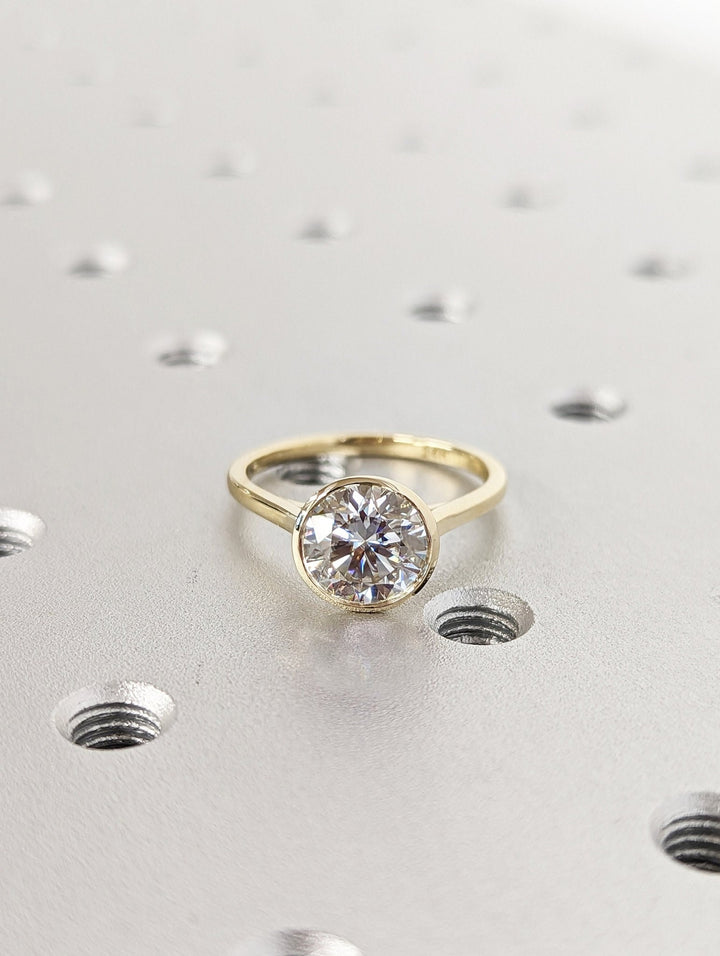 Round bezel engagement ring shown on hand for true-to-life sizing
