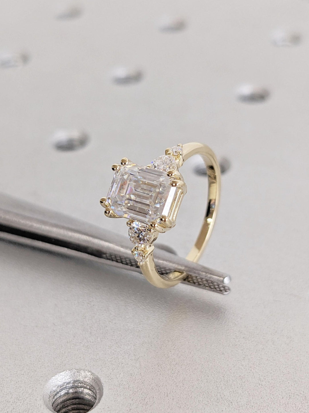 Emerald cut engagement ring shown with authenticity certificate