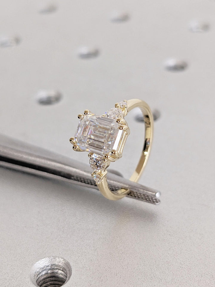 Emerald cut engagement ring shown with authenticity certificate