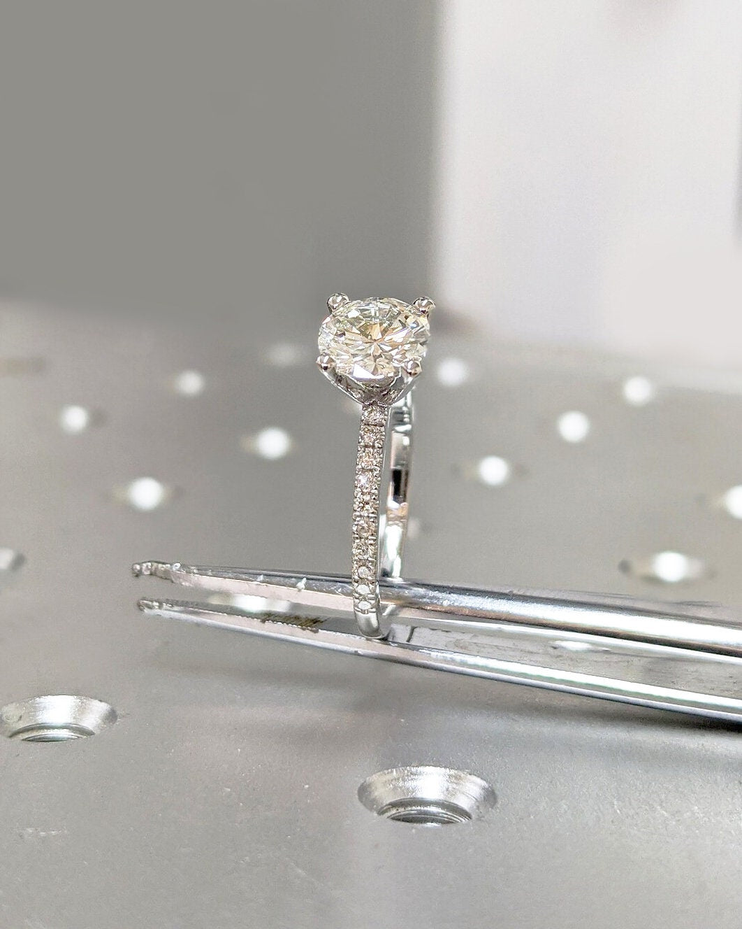 Round pave diamond ring displayed on jewelry stand