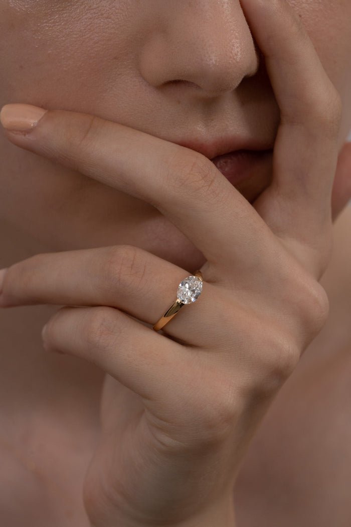 Oval east west diamond ring displayed on jewelry stand