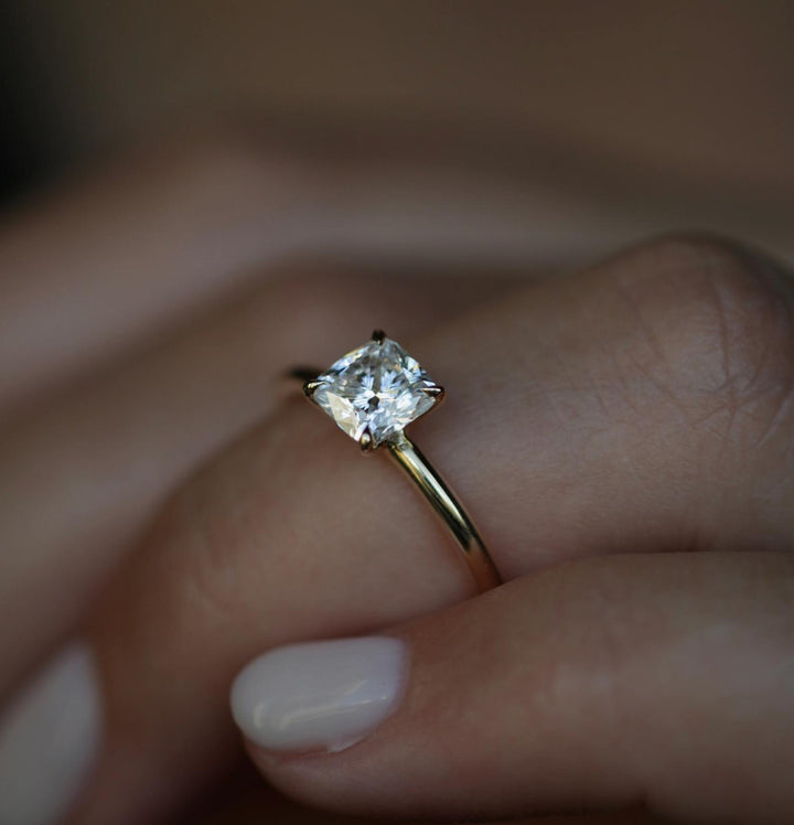 Cushion cut engagement ring shown with authenticity certificate