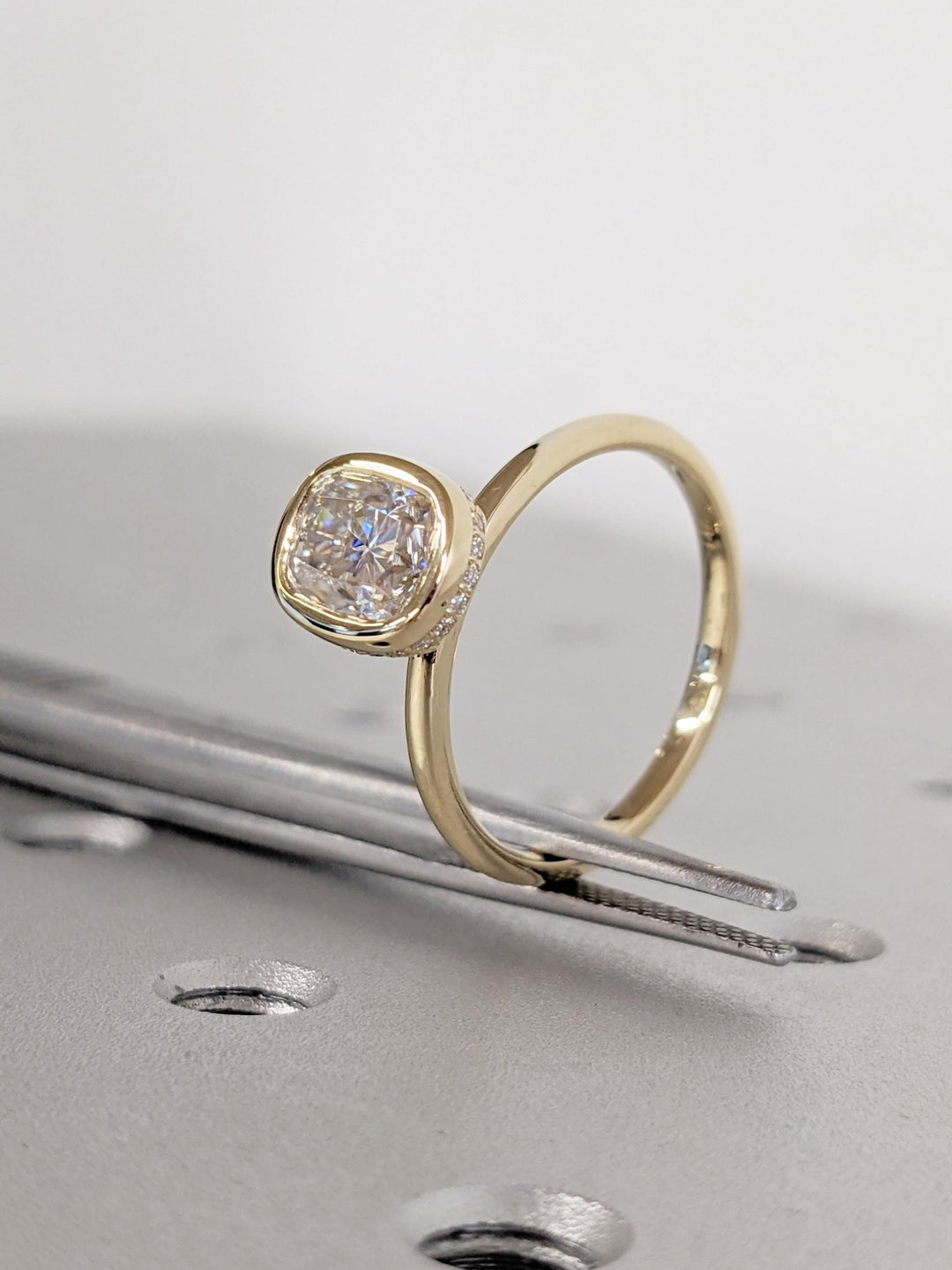 Detailed close-up of cushion hidden halo diamond engagement ring