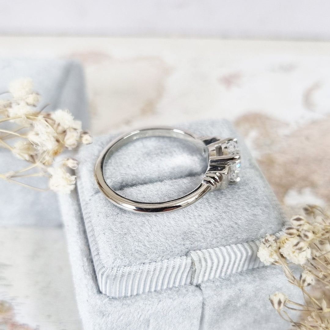 Lifestyle shot of cushion three stone diamond ring on hand