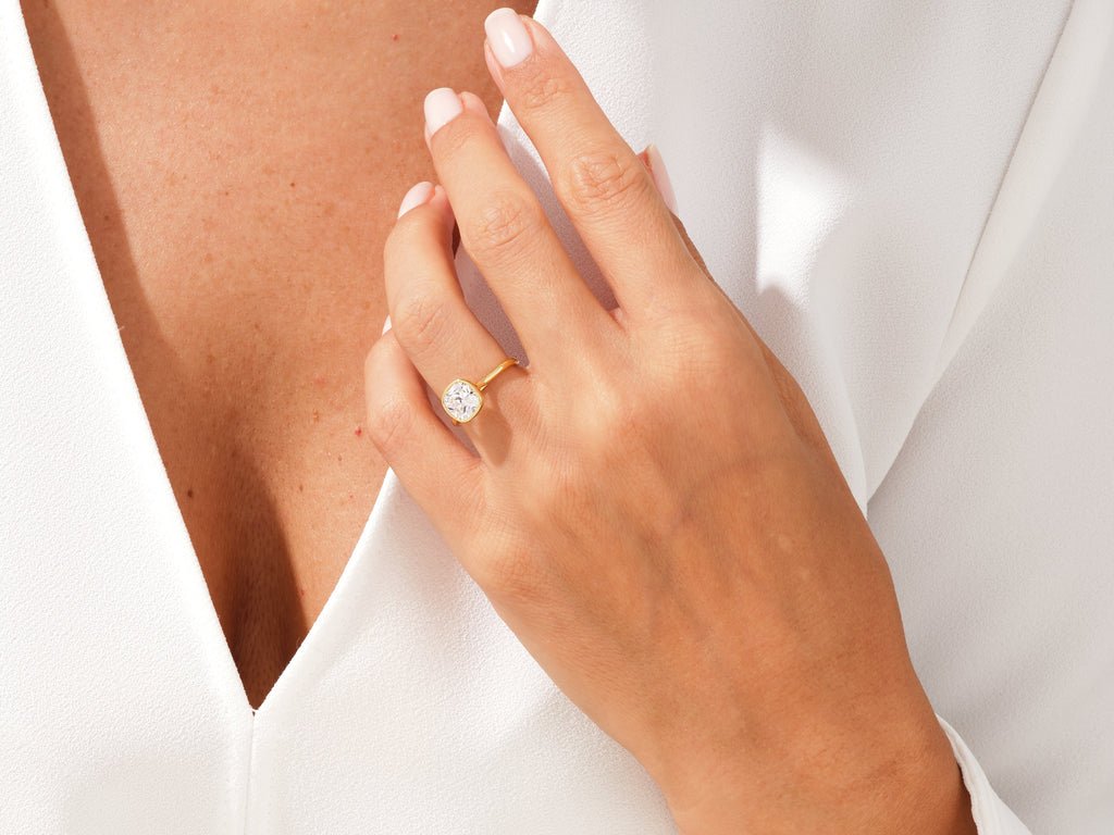 Close-up of cushion cut center diamond in bezel engagement ring