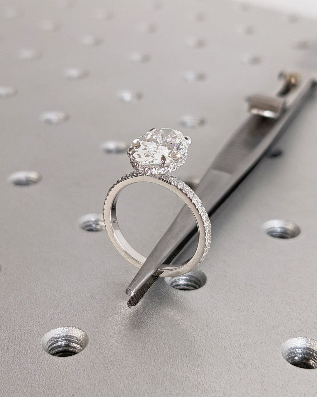 Oval hidden halo ring set with an IGI graded diamond