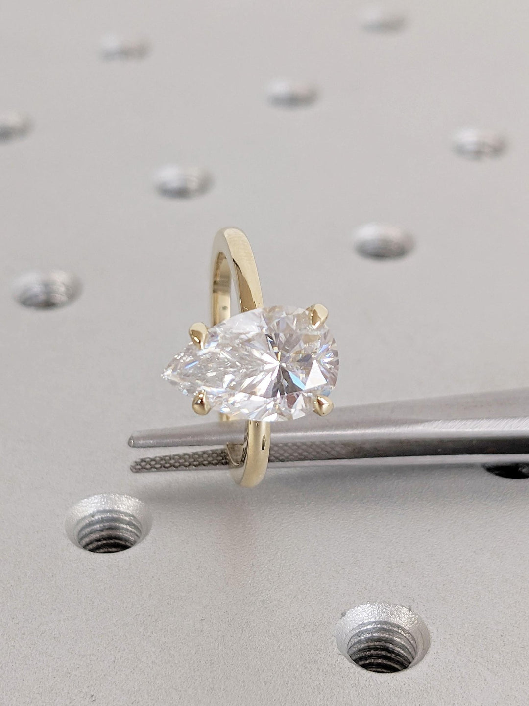 Pear hidden halo engagement ring offered in gold and platinum