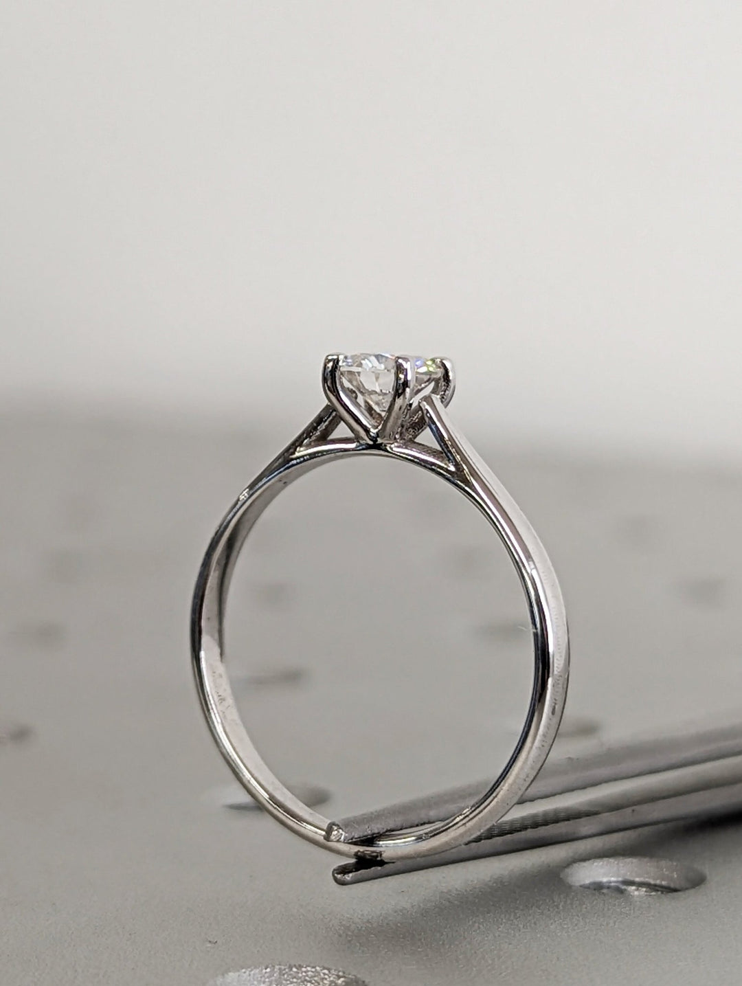 Lifestyle shot of round solitaire diamond ring on hand