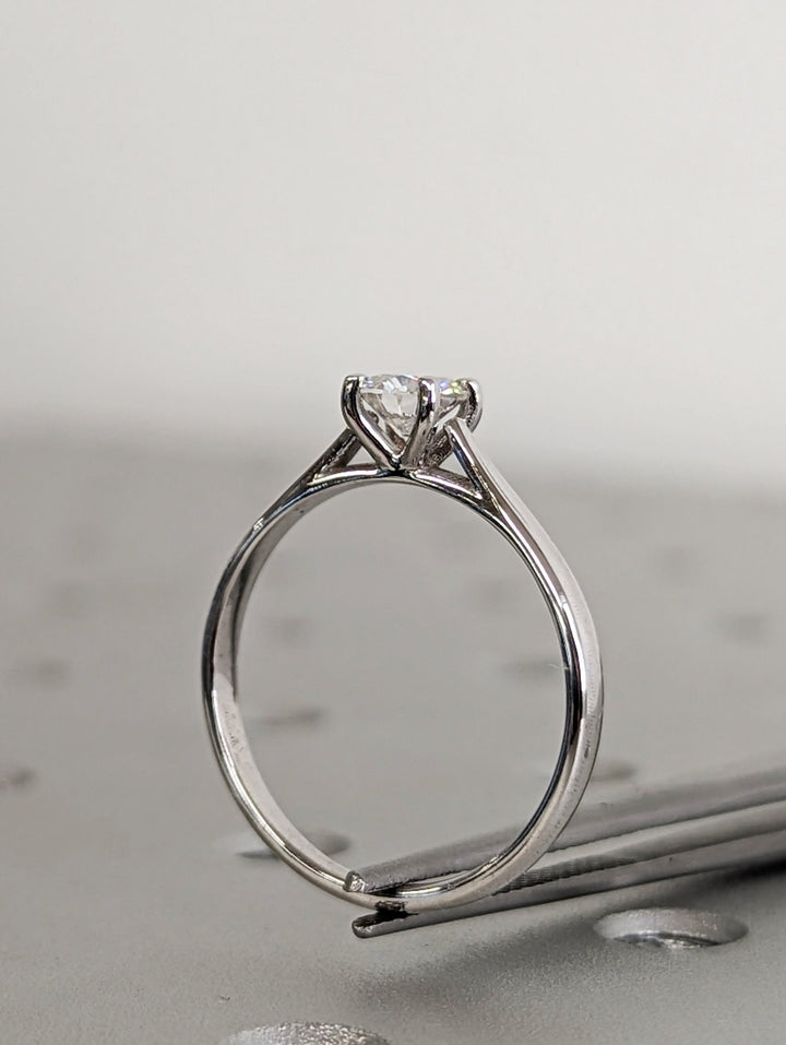 Lifestyle shot of round solitaire diamond ring on hand
