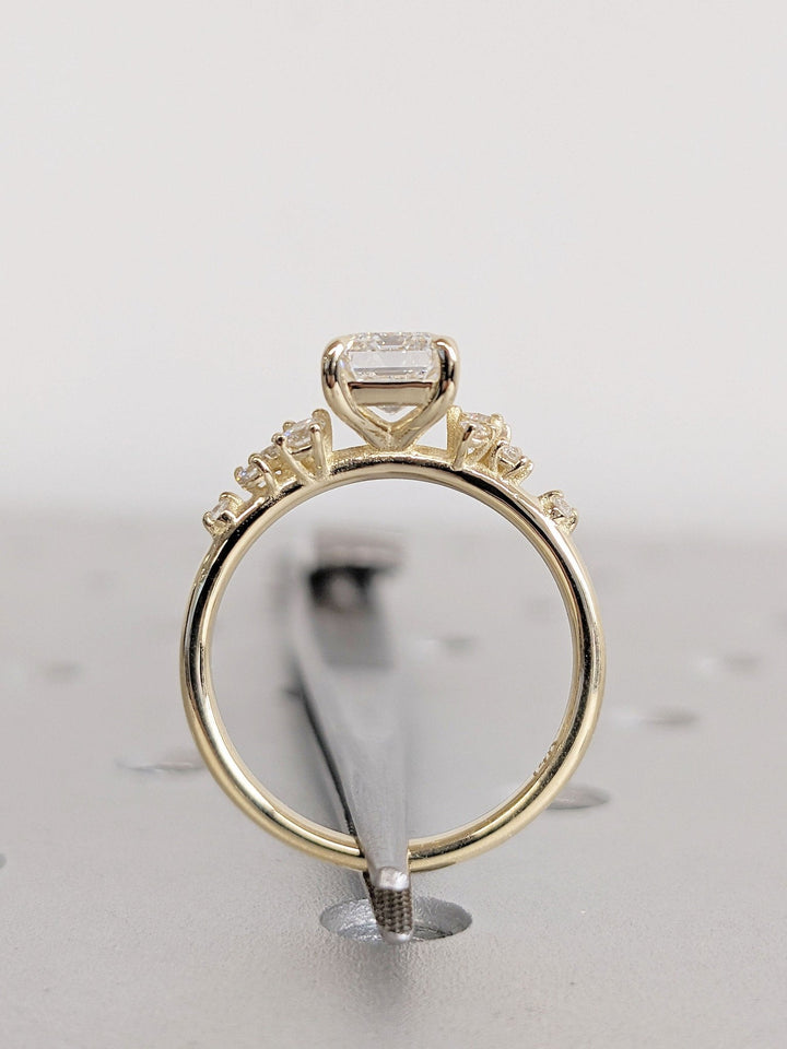 Emerald cluster engagement ring viewed from the side