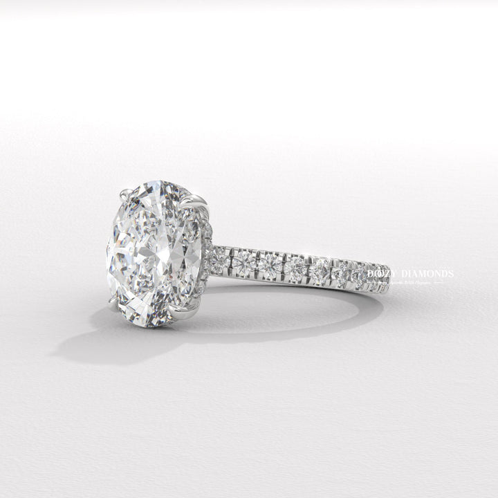 Oval hidden halo engagement ring viewed from the side