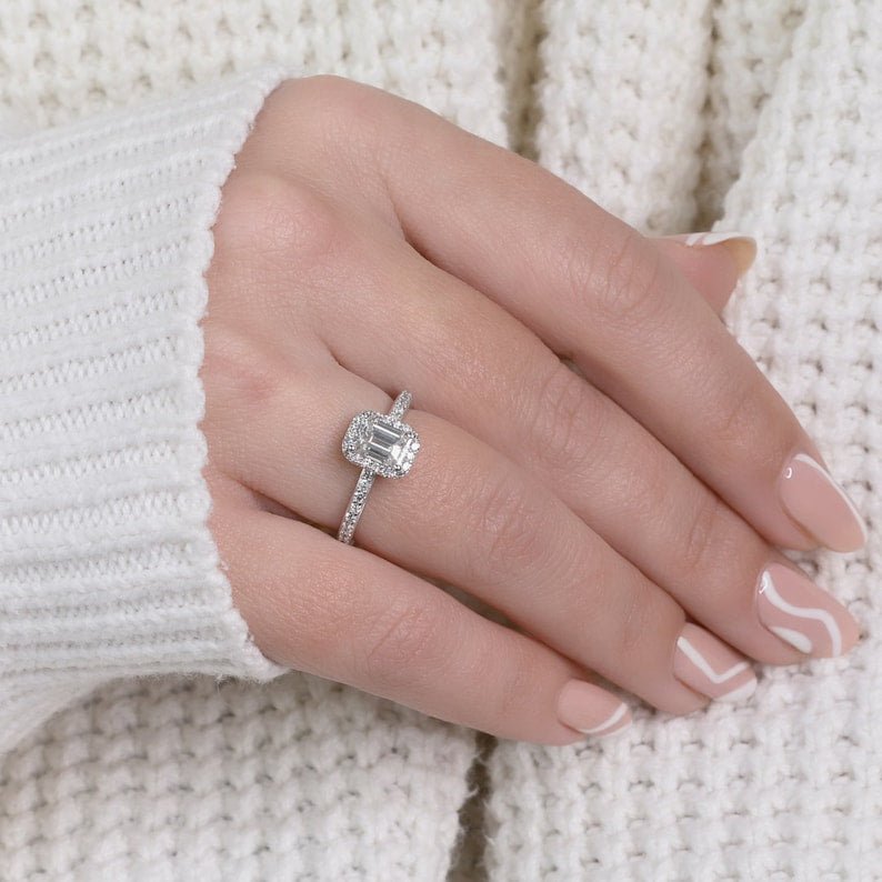Emerald cut halo engagement ring shown in real-life wear