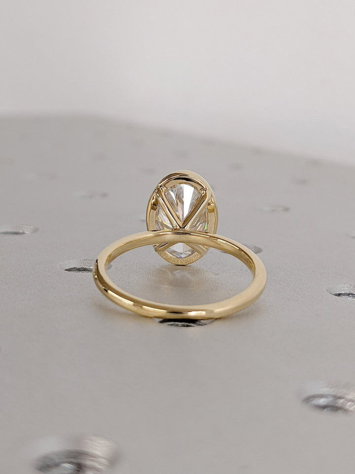 Oval bezel diamond engagement ring available in multiple metals