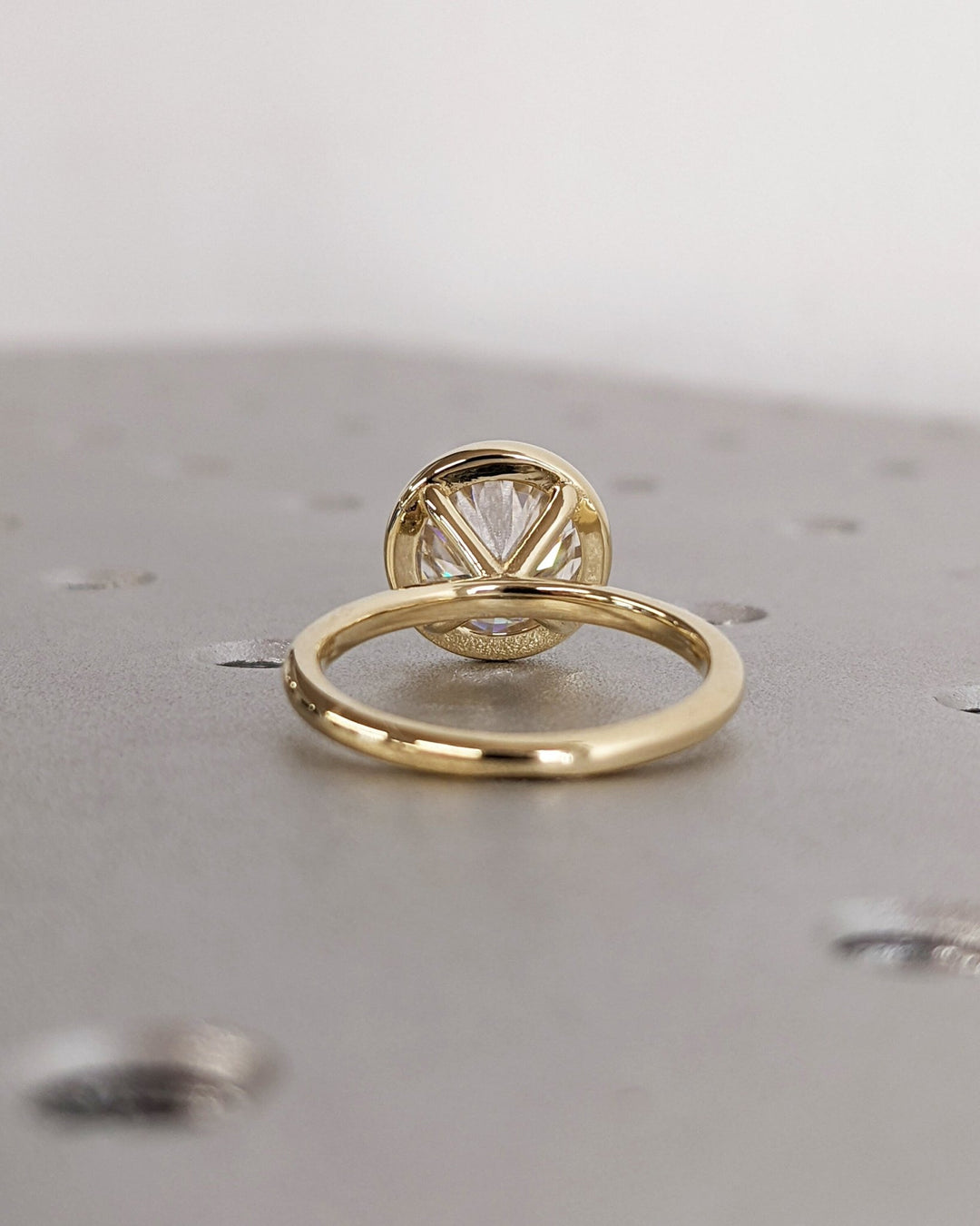 Round bezel engagement ring viewed from the side
