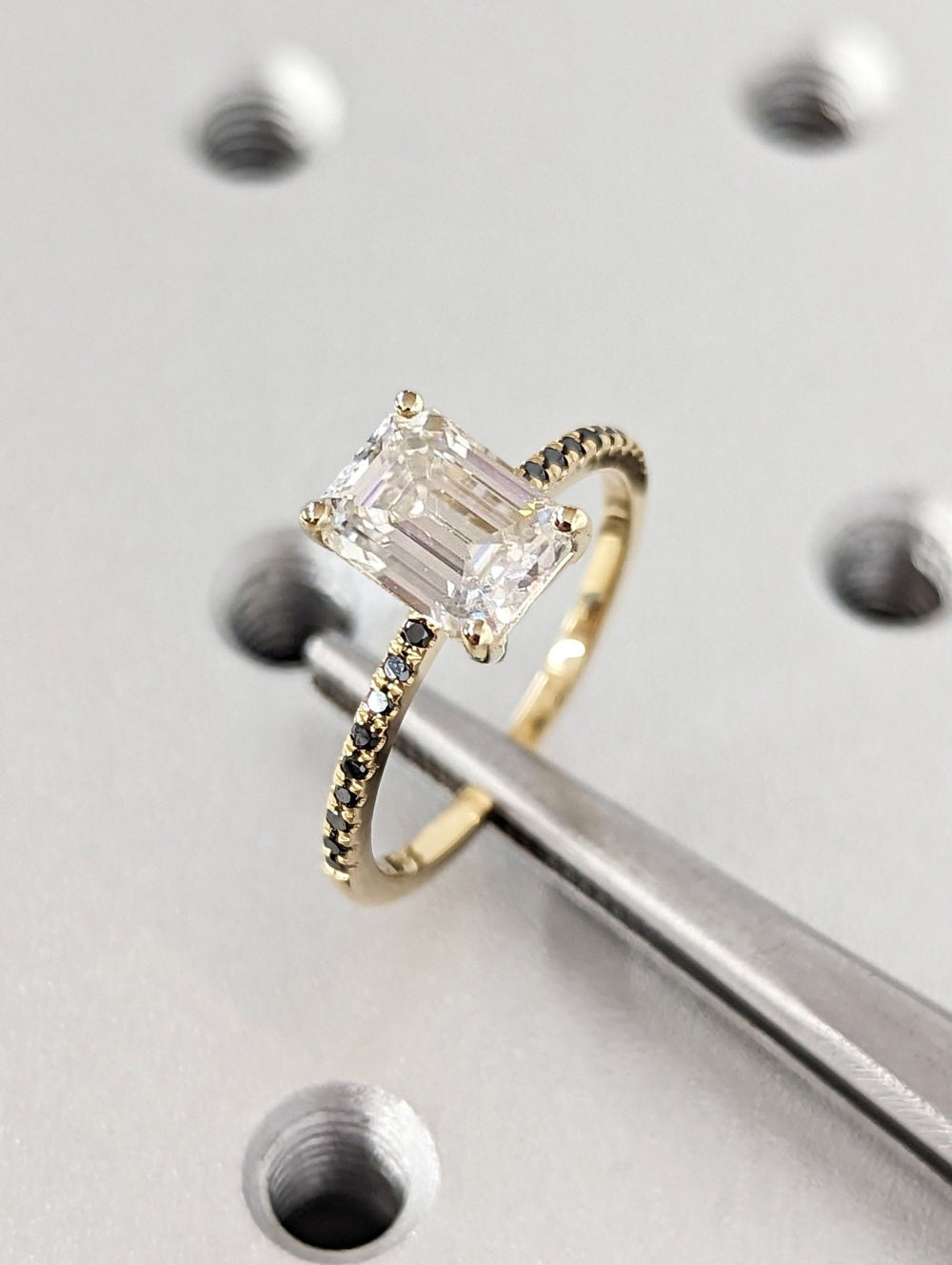 Close-up of emerald cut center diamond in pave engagement ring