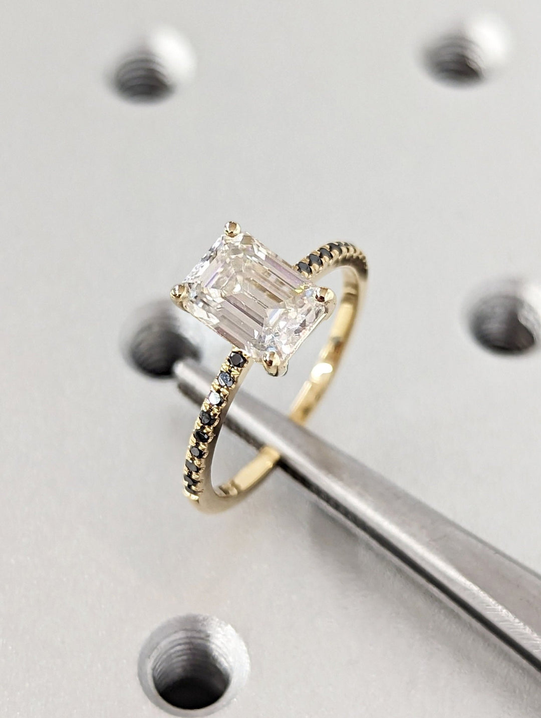 Close-up of emerald cut center diamond in pave engagement ring