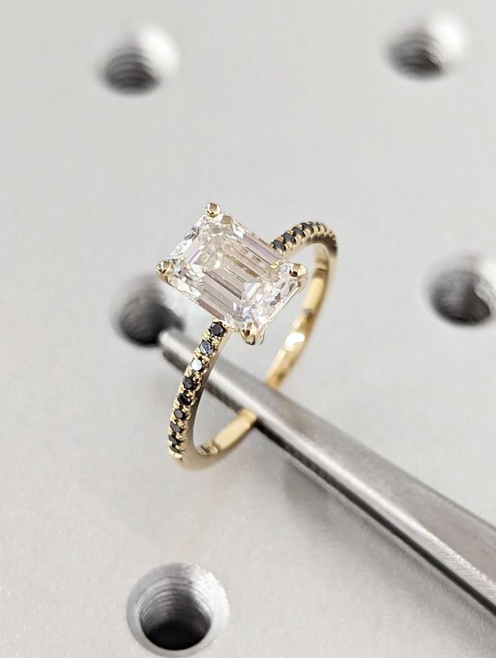 Close-up of emerald cut center diamond in pave engagement ring