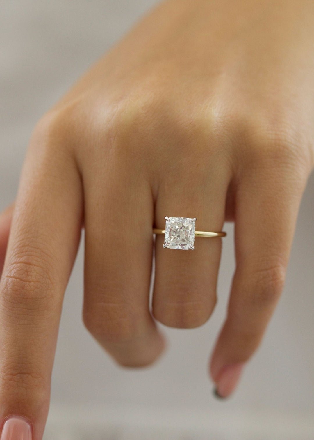 Lifestyle shot of cushion hidden halo diamond ring on hand