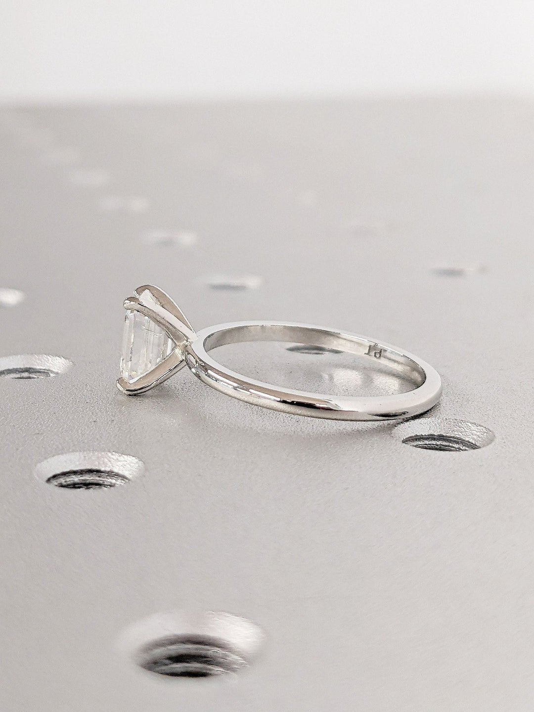 Detailed close-up of emerald solitaire diamond engagement ring