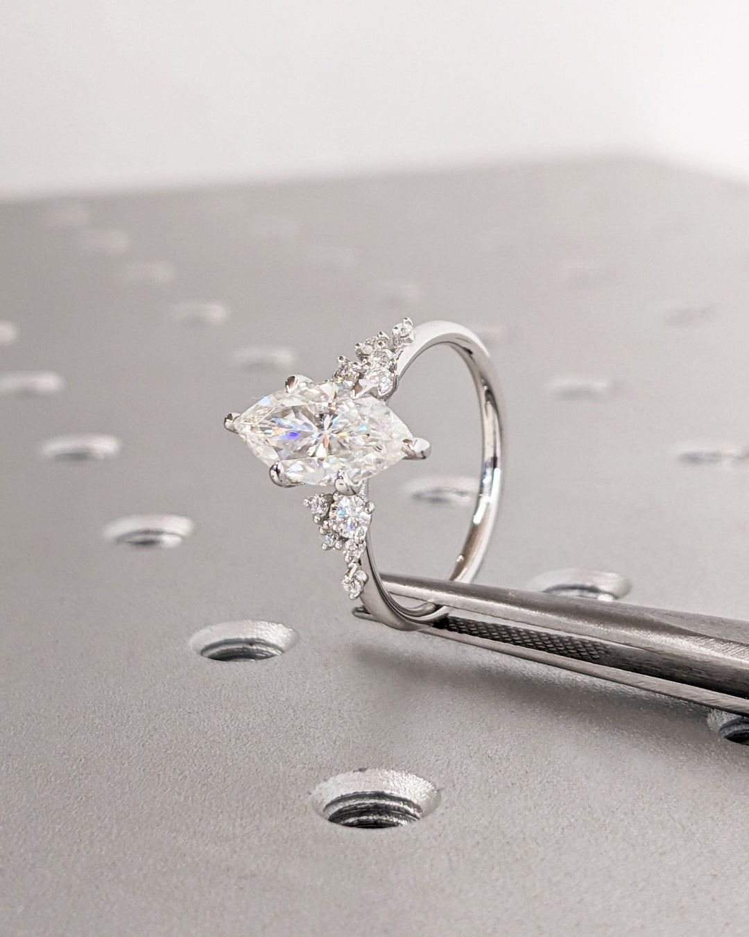Certified marquise cut diamond featured in cluster engagement ring