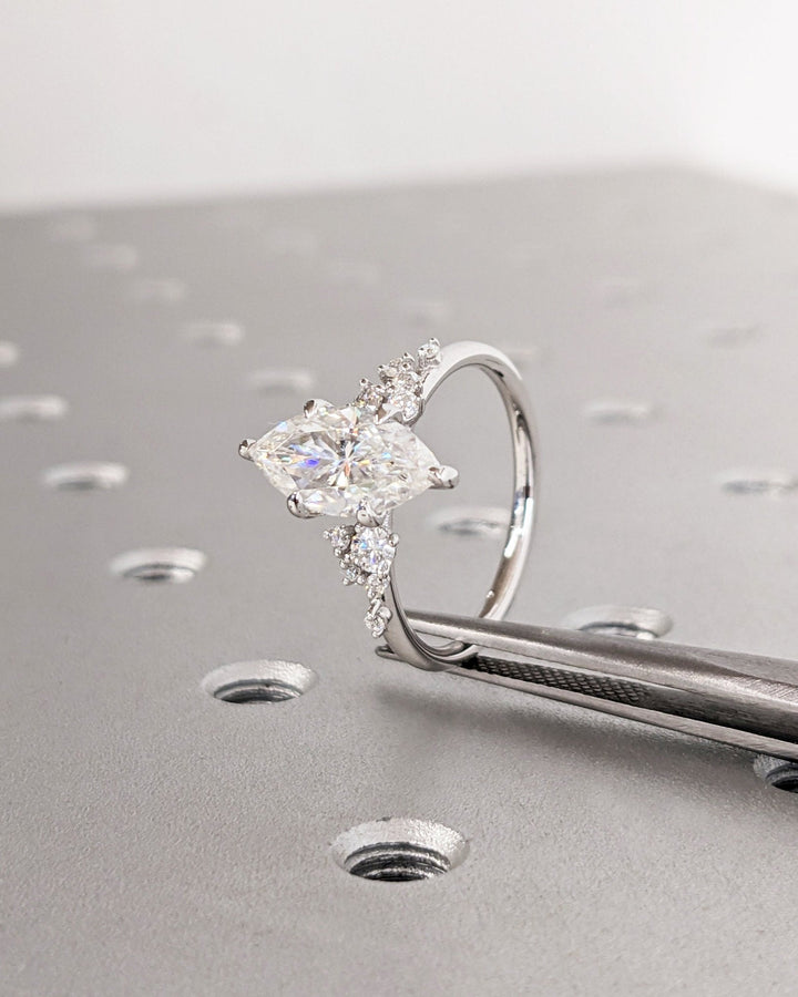 Certified marquise cut diamond featured in cluster engagement ring