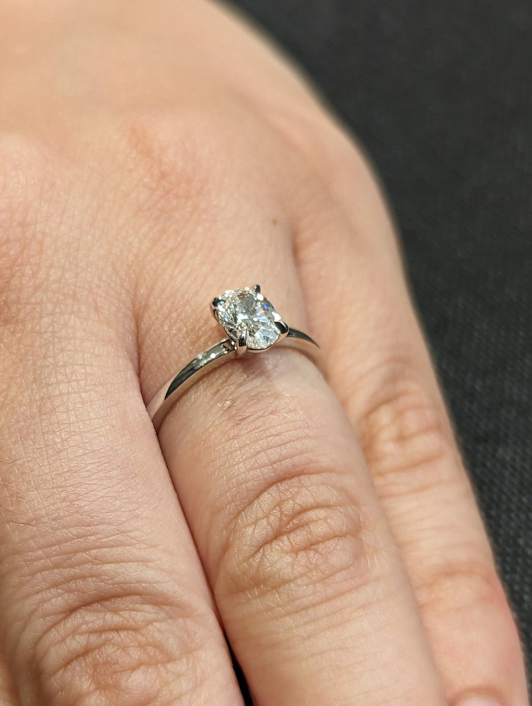 Detailed close-up of oval solitaire diamond engagement ring