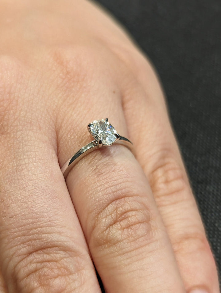 Detailed close-up of oval solitaire diamond engagement ring