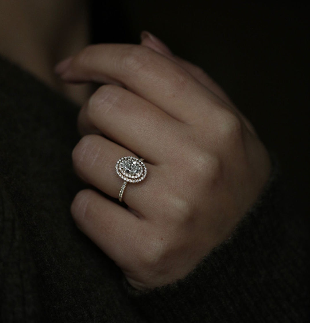 Oval cut halo engagement ring shown in real-life wear