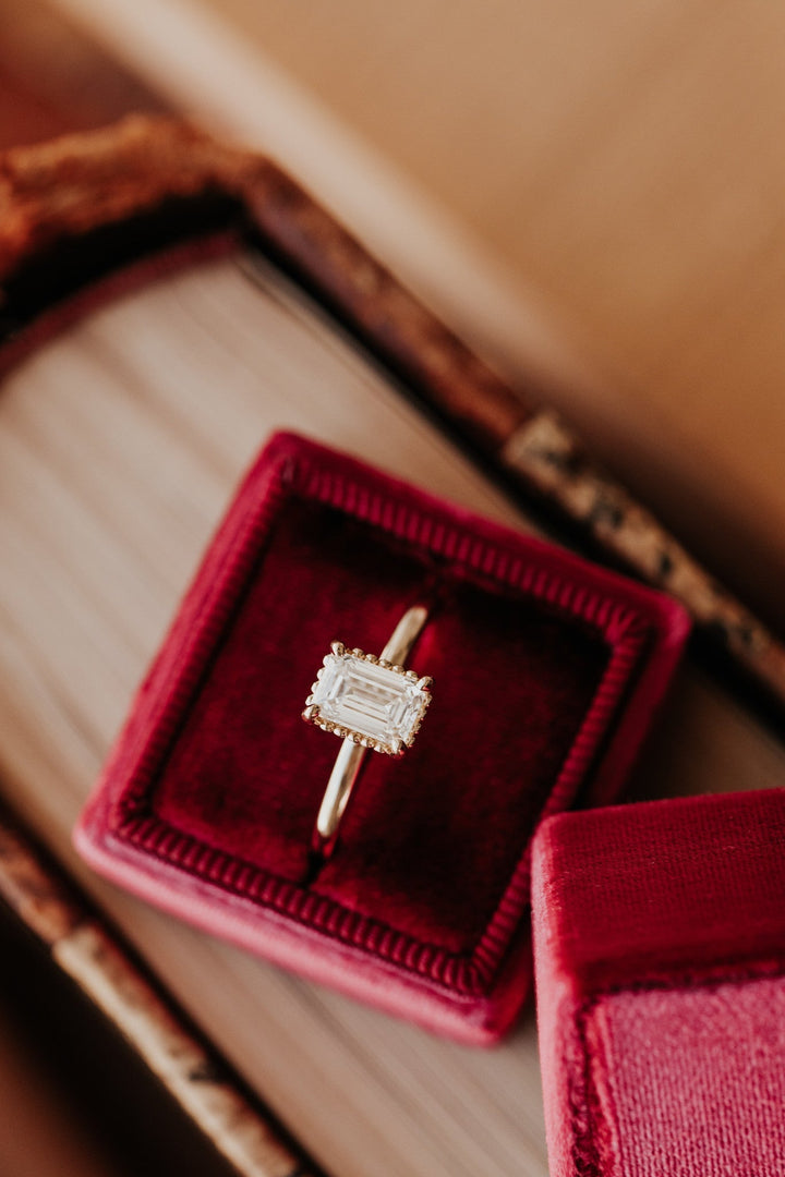 Emerald cut engagement ring shown with authenticity certificate