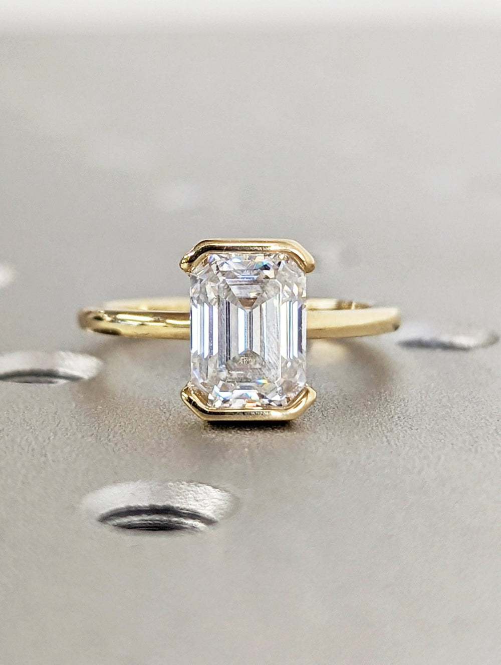Lifestyle shot of emerald bezel diamond ring on hand
