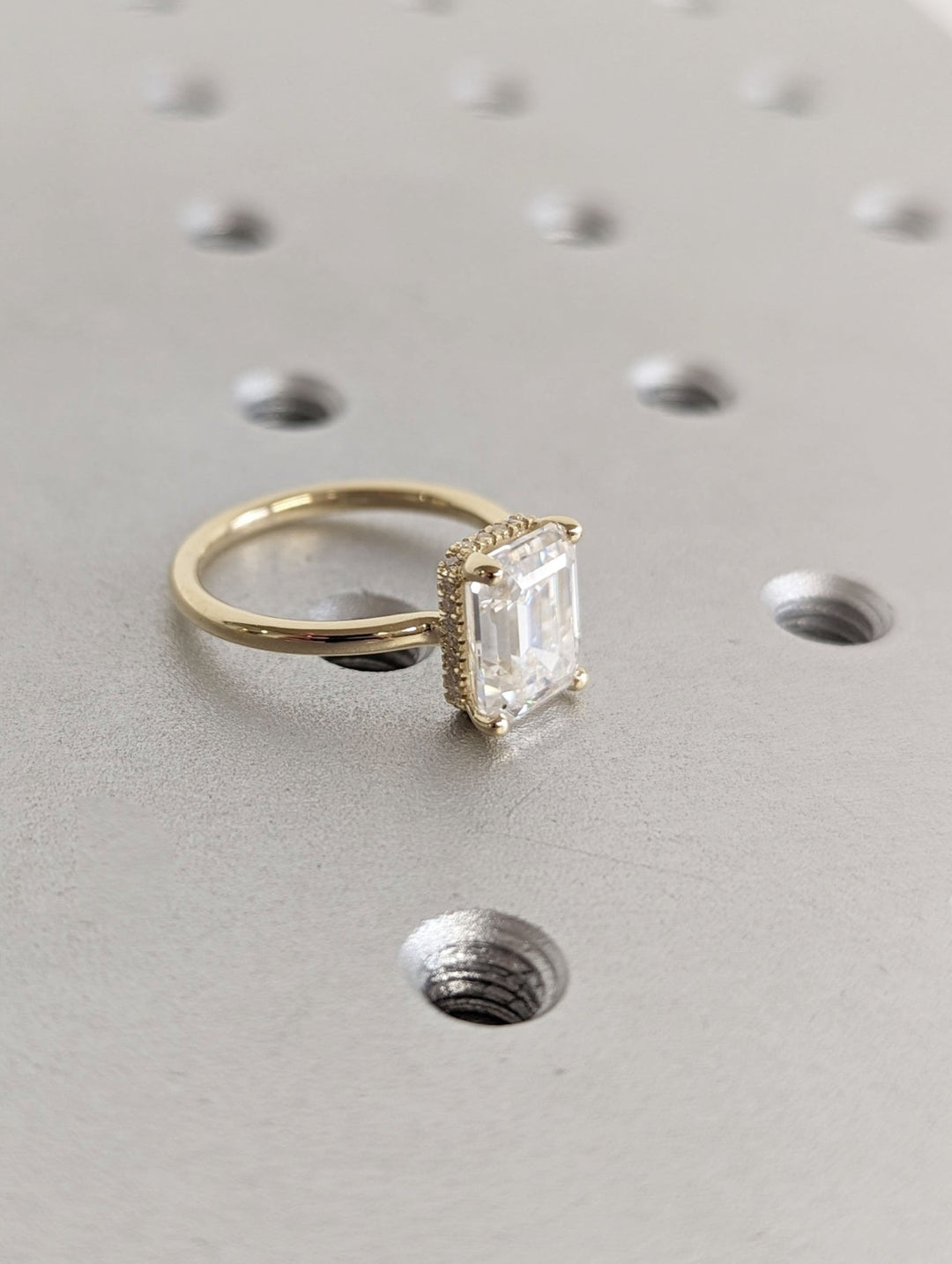 Profile view of emerald cut hidden halo engagement ring band