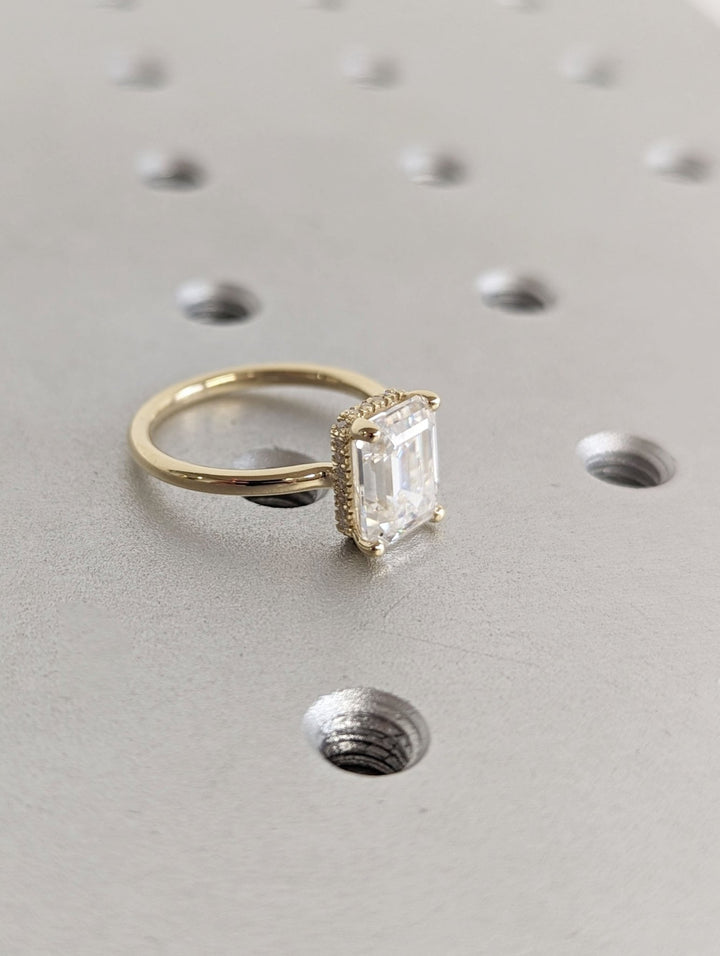 Profile view of emerald cut hidden halo engagement ring band