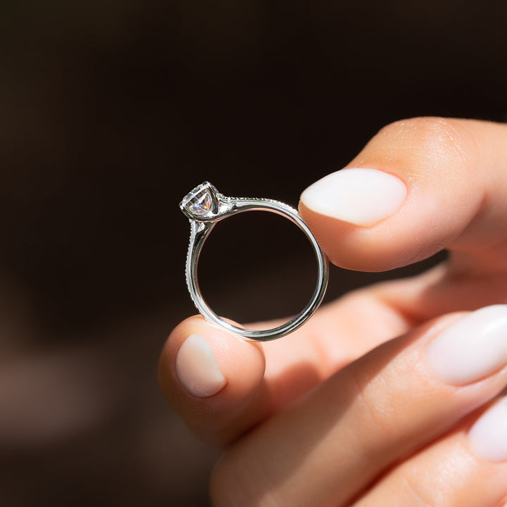 Cushion cut engagement ring shown with authenticity certificate