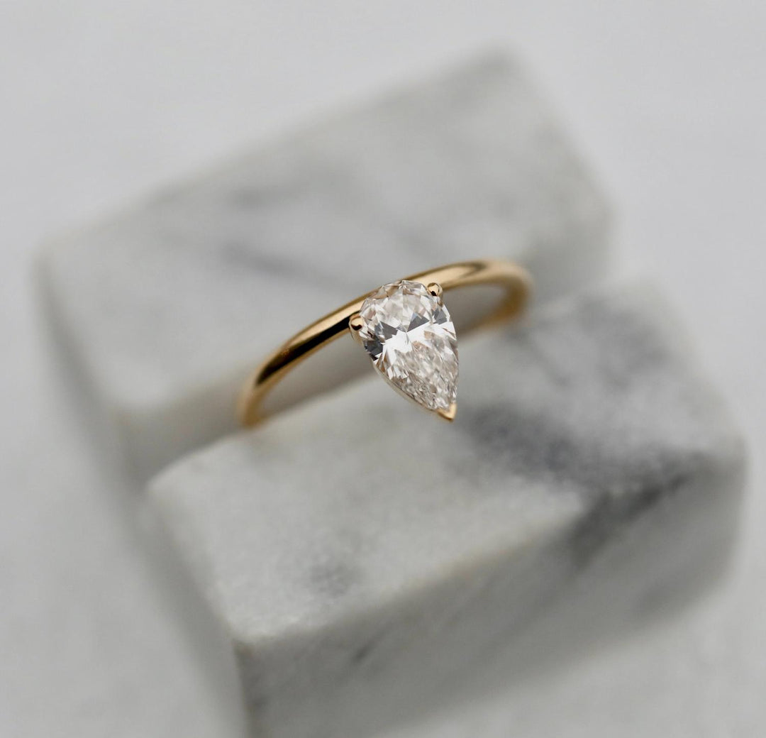 Pear solitaire engagement ring finished in polished solid gold