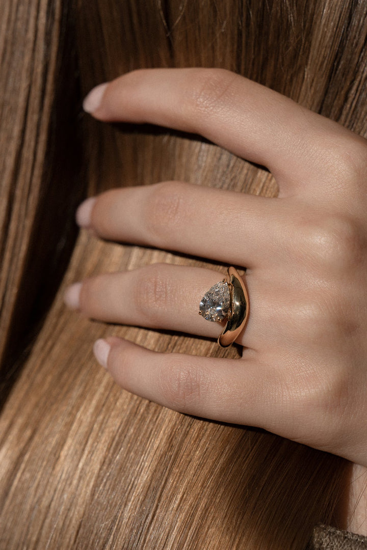 Pear dome ring set with an IGI graded diamond