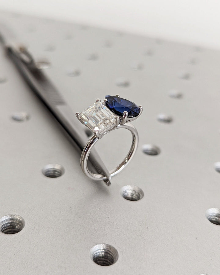 Emerald cut engagement ring shown with authenticity certificate