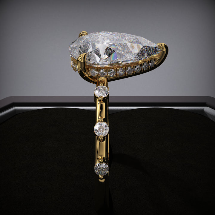 Close-up of pear cut center diamond in hidden halo engagement ring