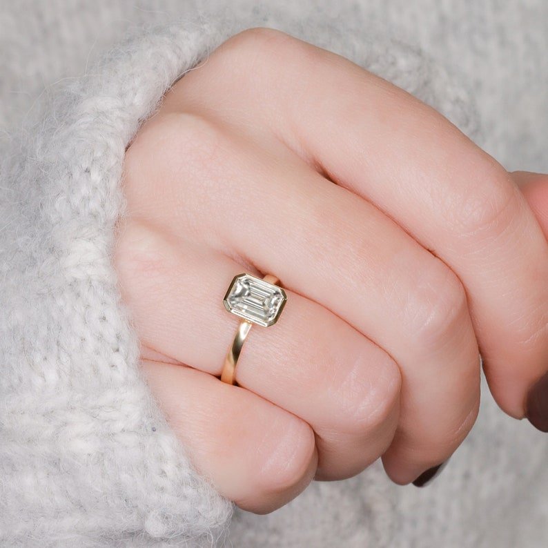 Emerald bezel diamond ring presented in signature gift packaging