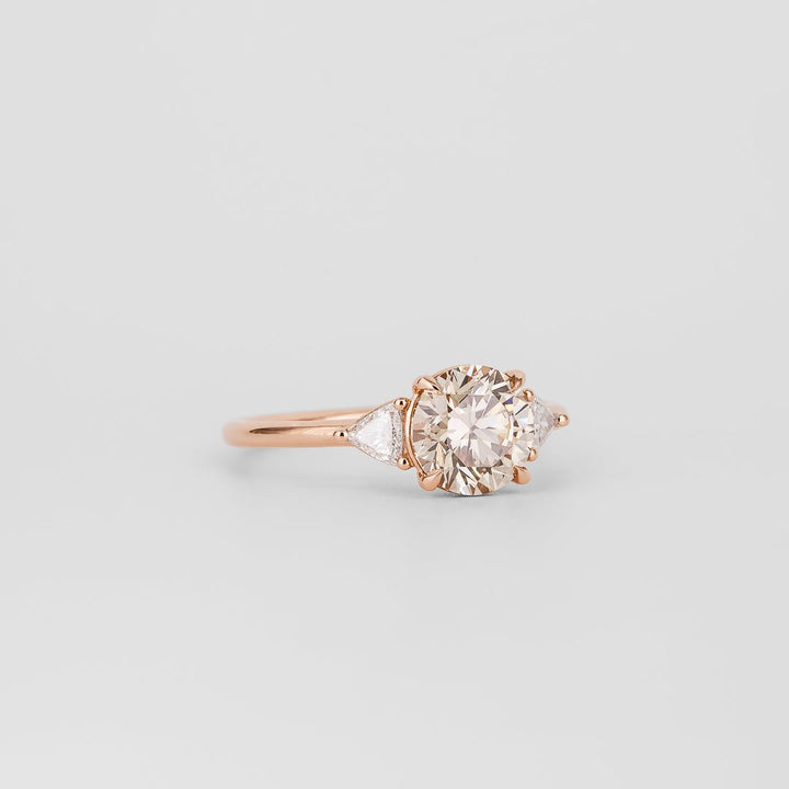 Angled view of round cut diamond in three stone setting