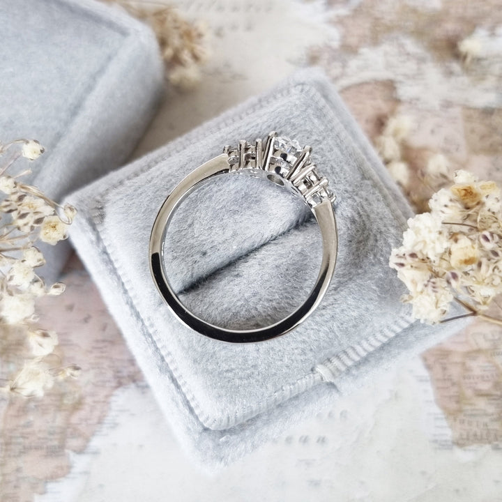 Oval cluster engagement ring viewed from the side