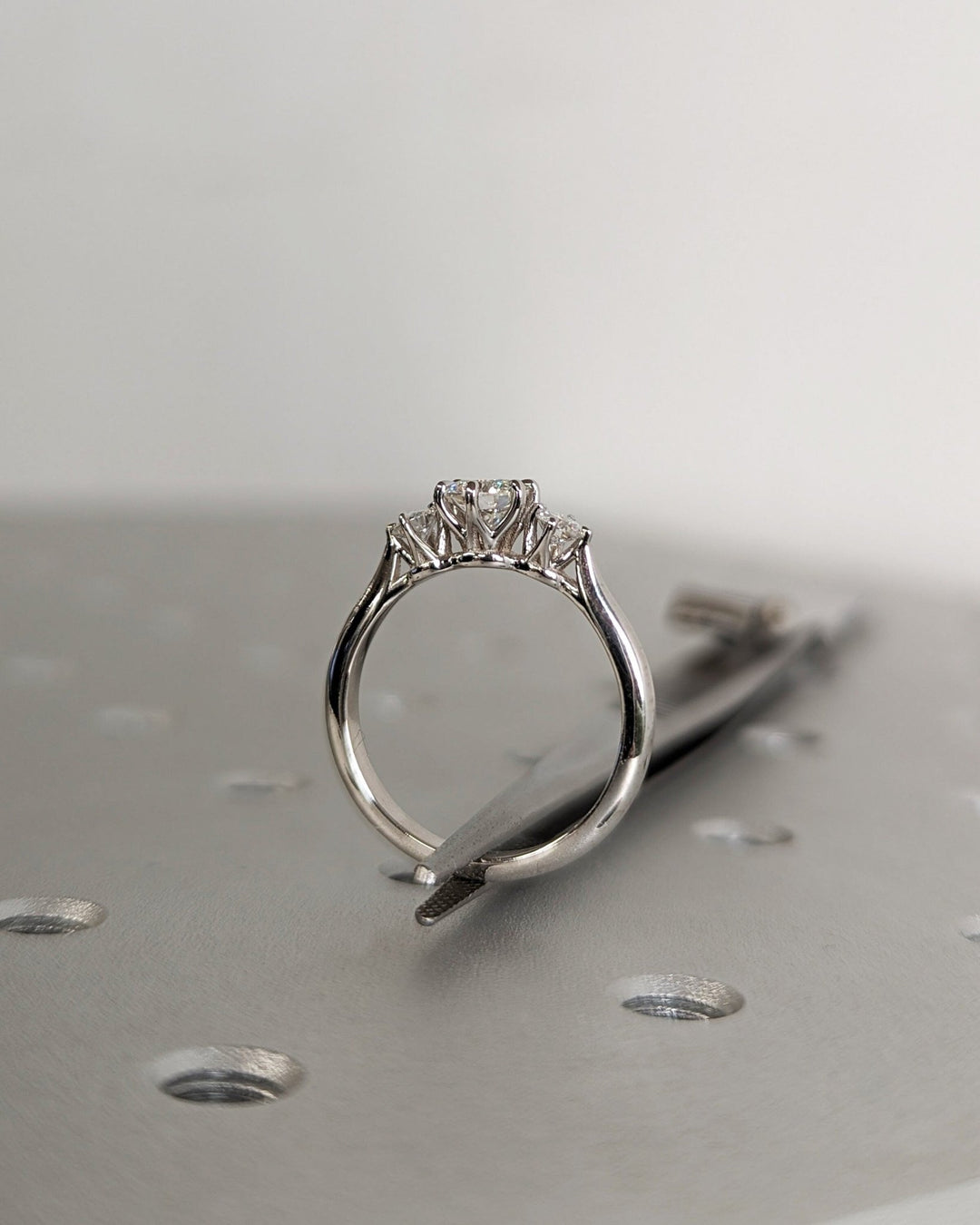 Round three stone engagement ring close-up showing high clarity diamond clarity