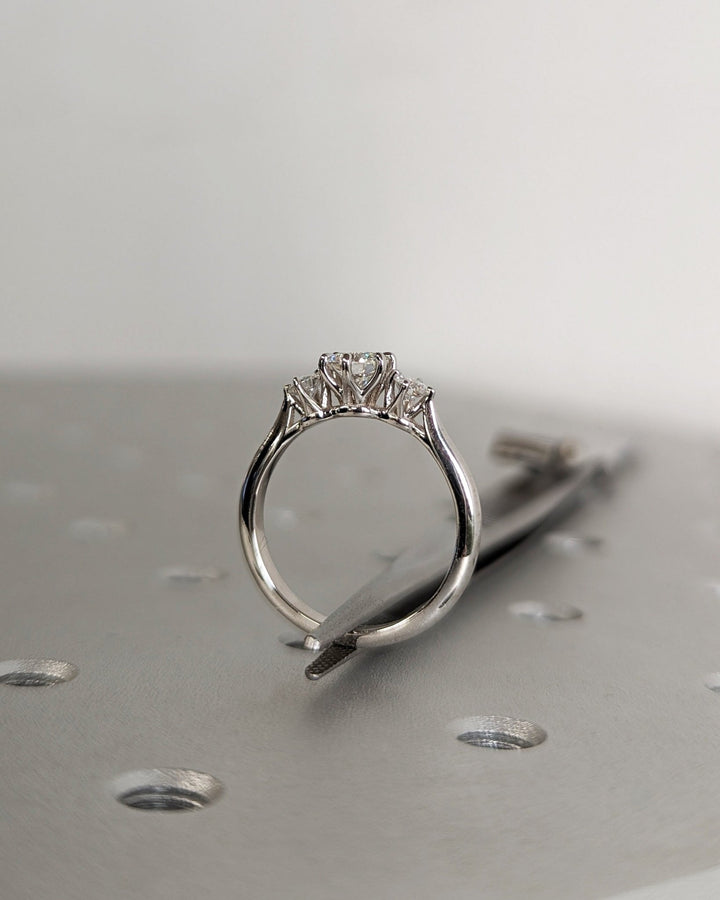 Round three stone engagement ring close-up showing high clarity diamond clarity