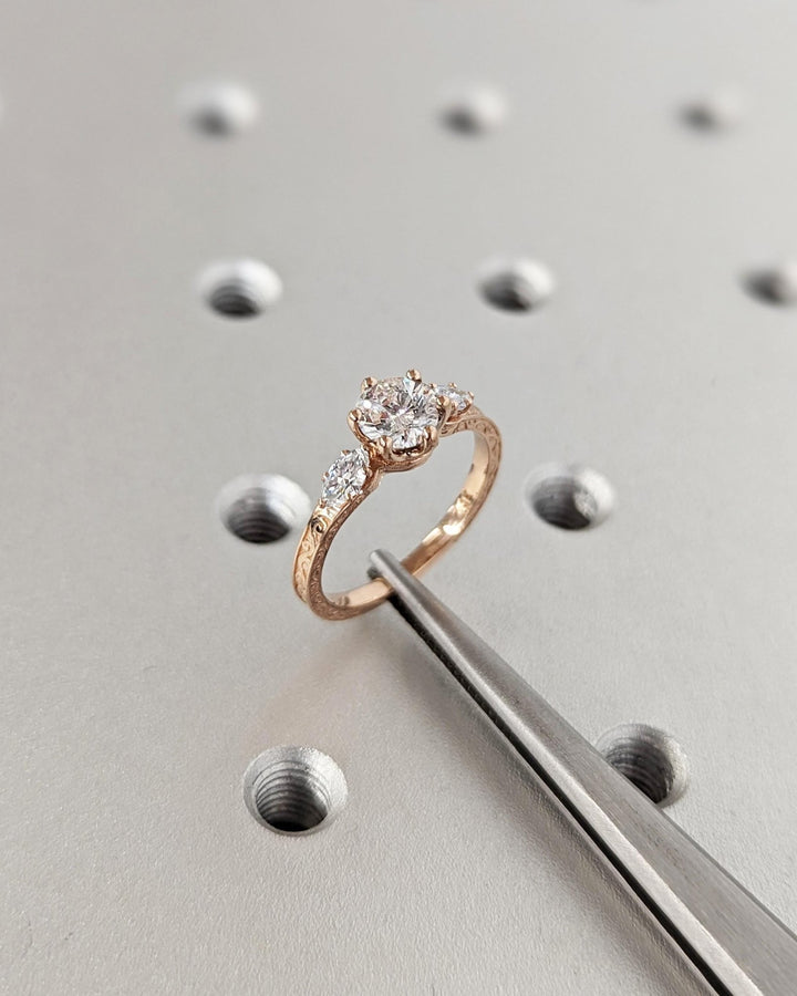 Round three stone engagement ring offered in gold and platinum