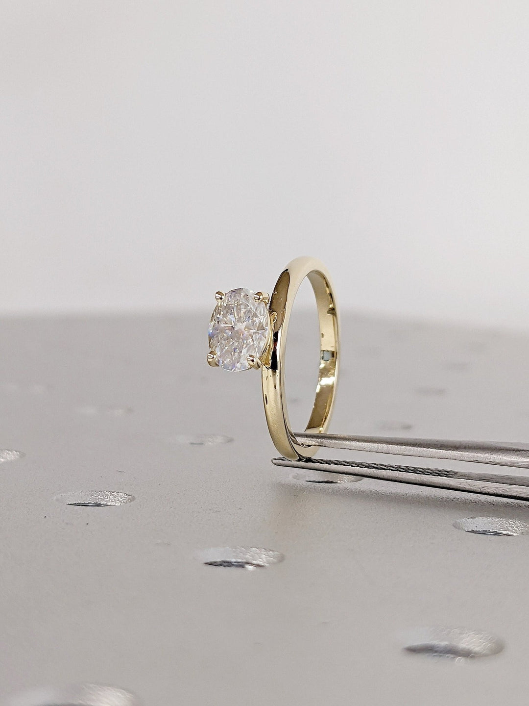 Oval east west diamond ring displayed on jewelry stand